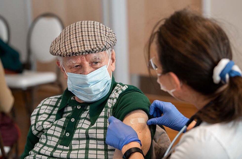 holocaust survivor getting a vaccination at a free clinic event