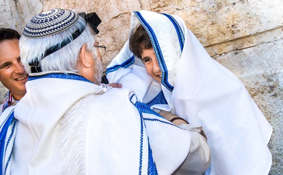 boy celebrating his bar mitzvah with a rabbi