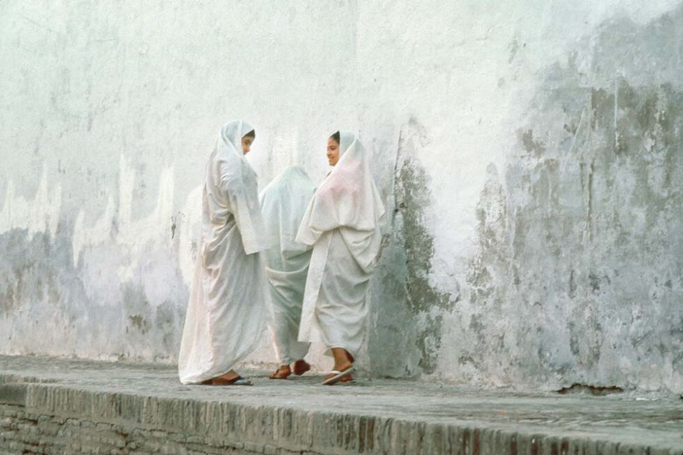 group of veiled women standing by a wall