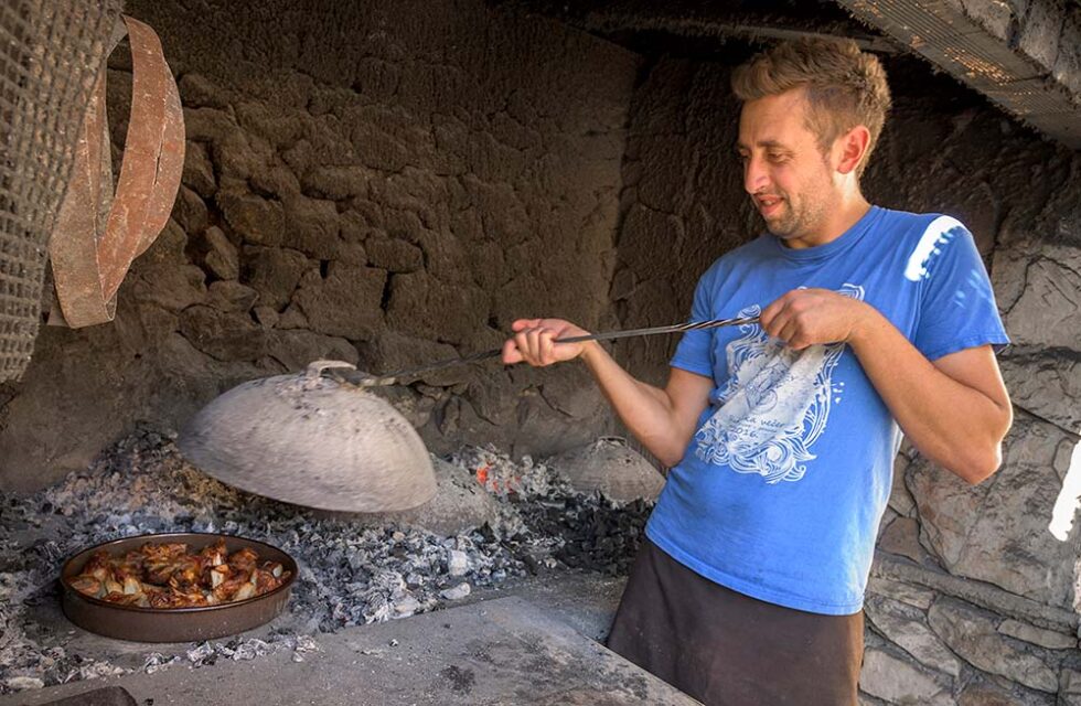 man cooking over a woodfired oven